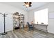 Bright home office featuring a wooden desk, ceiling fan, wood-look floors, and a decorative bookshelf at 7426 Blue Water Ln, Castle Rock, CO 80108