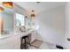 Bright bathroom featuring dual sinks, vanity, stool, stylish lighting and decorative mirror at 17046 Desert Wine Trl, Parker, CO 80134