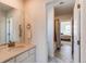 Bright bathroom featuring a large mirror reflecting the doorway to the bedroom and a sink with modern bronze fixtures at 17046 Desert Wine Trl, Parker, CO 80134