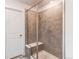 Tiled shower featuring glass enclosure with bench seating and modern fixtures at 17046 Desert Wine Trl, Parker, CO 80134