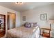 Cozy bedroom with a stylish brown patterned bed, wooden side table, and ensuite bathroom at 17046 Desert Wine Trl, Parker, CO 80134