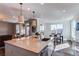 Bright, modern kitchen with large island, stainless steel sink, and pendant lighting in an open floor plan at 17046 Desert Wine Trl, Parker, CO 80134