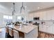 Modern kitchen with white cabinets, a large island with seating, and stainless steel appliances at 17046 Desert Wine Trl, Parker, CO 80134