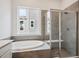Modern bathroom featuring a soaking tub under a window and a glass enclosed shower at 9197 Ironwood St, Highlands Ranch, CO 80129