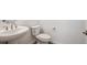 Powder room featuring a modern pedestal sink, toilet, and brushed nickel hardware at 9197 Ironwood St, Highlands Ranch, CO 80129
