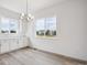 Sunlit dining area features large windows offering views of the neighborhood, complemented by modern light fixture at 9197 Ironwood St, Highlands Ranch, CO 80129