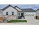 Charming exterior featuring stone accents, white siding, and a two-car garage at 9197 Ironwood St, Highlands Ranch, CO 80129