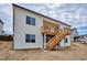 Modern white two-story home featuring a wooden staircase leading to a private balcony and large windows at 9197 Ironwood St, Highlands Ranch, CO 80129