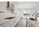 This modern kitchen boasts white subway tile backsplash, stainless hood, and spacious quartz countertops at 9197 Ironwood St, Highlands Ranch, CO 80129