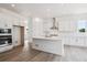 Bright kitchen features white cabinets, stainless steel appliances, and large island with quartz countertops at 9197 Ironwood St, Highlands Ranch, CO 80129