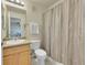 This bathroom features a sink, toilet, and shower behind a tan shower curtain at 5660 S Algonquian Way # A, Aurora, CO 80016