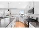 Modern kitchen with white cabinets, corner sink, and hardwood floors at 5245 W 97Th Ave, Broomfield, CO 80020