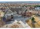 Aerial view of large brick home with three-car garage and extensive driveway at 6854 Carr St, Arvada, CO 80004