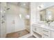 Bright bathroom featuring a glass walk-in shower with rain shower head and a white vanity at 6854 Carr St, Arvada, CO 80004