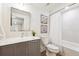 Cozy bathroom showcases a vanity with gray cabinets, framed floral prints, and a shower-tub combo at 6854 Carr St, Arvada, CO 80004