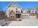 Charming two-story home with brick and gray siding and an attached two-car garage on a sunny day at 6854 Carr St, Arvada, CO 80004