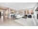 Open-concept living area featuring a white couch, black chairs, and a view of the kitchen with barstool seating at 6854 Carr St, Arvada, CO 80004