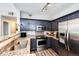 Well-lit kitchen with stainless steel appliances, granite counters, and stylish dark blue cabinetry at 8500 E Jefferson Ave # 19B, Denver, CO 80237