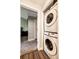 Laundry area with stacked washer and dryer, with carpet in the bedroom area seen through the door at 8500 E Jefferson Ave # 19B, Denver, CO 80237