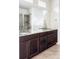 Bathroom with double granite vanity, wood cabinets, and a glass-enclosed shower with stone-look tiling at 8844 S Sicily Ct, Aurora, CO 80016