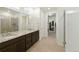 A full bathroom with tile flooring, granite counters, double sinks, and easy access to laundry at 8844 S Sicily Ct, Aurora, CO 80016