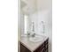 Bathroom vanity with a large mirror and silver hardware with a neutral countertop and dark cabinets at 8844 S Sicily Ct, Aurora, CO 80016