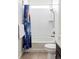 Bright bathroom featuring a tub with white tile, a shower, a patterned shower curtain, and a modern toilet at 8844 S Sicily Ct, Aurora, CO 80016