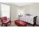 Cozy bedroom area with red accents, comfortable seating, and natural light from the window at 8844 S Sicily Ct, Aurora, CO 80016