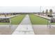 Outdoor bocce ball court with lush green turf, benches, and walkway in a well-maintained community at 8844 S Sicily Ct, Aurora, CO 80016