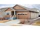 Inviting home featuring a brick facade, a manicured lawn, and a front yard rock garden at 8844 S Sicily Ct, Aurora, CO 80016