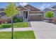 Charming two-story home featuring a stone facade, two-car garage, and well-maintained landscaping at 8844 S Sicily Ct, Aurora, CO 80016