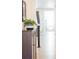 Bright hallway featuring hardwood floors, a cabinet with plant, and an open view into the living room at 8844 S Sicily Ct, Aurora, CO 80016