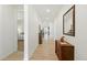 Long hallway with light wood floors, white walls, leading to the bedroom and kitchen at 8844 S Sicily Ct, Aurora, CO 80016