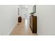 Bright hallway with wood floors, decorative furniture, and a view of the front door at 8844 S Sicily Ct, Aurora, CO 80016