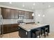 A modern kitchen with stainless steel appliances, granite counters, and a large center island with breakfast bar at 8844 S Sicily Ct, Aurora, CO 80016