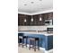 Kitchen island with bar stool seating, stylish pendant lights, and rich dark cabinetry at 8844 S Sicily Ct, Aurora, CO 80016