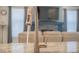 Close-up of a kitchen faucet with the living room and fireplace in the background at 8844 S Sicily Ct, Aurora, CO 80016