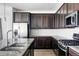 Modern kitchen with dark wood cabinets, stainless steel appliances, and granite countertops at 8844 S Sicily Ct, Aurora, CO 80016