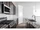 Modern kitchen with stainless steel appliances, granite counters, and sleek dark cabinetry at 8844 S Sicily Ct, Aurora, CO 80016