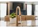 A close up of the kitchen faucet with a large television in the background at 8844 S Sicily Ct, Aurora, CO 80016