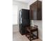 Laundry room with stacked washer and dryer set, wooden storage cabinet and a small wooden table at 8844 S Sicily Ct, Aurora, CO 80016