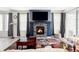 Cozy living room showcasing a fireplace with a TV above it, and a patchwork area rug at 8844 S Sicily Ct, Aurora, CO 80016
