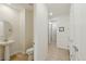 A clean and well-lit powder room with a pedestal sink and views into the hallway at 8844 S Sicily Ct, Aurora, CO 80016