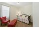 Cozy carpeted room features a daybed, a red chair, and an ottoman at 8844 S Sicily Ct, Aurora, CO 80016