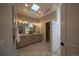 Luxury bathroom with a skylight, a dual vanity, and a separate walk-in shower at 367 Josef Cir, Fort Lupton, CO 80621