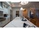 Kitchen island with white countertop, sink, and modern fixtures under a decorative light fixture at 367 Josef Cir, Fort Lupton, CO 80621