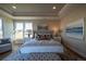 Well-lit main bedroom boasting a tray ceiling, large windows, and comfortable sitting area at 367 Josef Cir, Fort Lupton, CO 80621