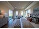 Bright main bedroom with tray ceiling, sitting area, and sliding glass door to the backyard at 367 Josef Cir, Fort Lupton, CO 80621