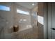 Modern walk-in shower featuring marble tile, a pebble floor, and a built-in bench at 367 Josef Cir, Fort Lupton, CO 80621