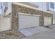 Attached two car garage features stone accents and a white garage door at 8833 Meade St, Westminster, CO 80031